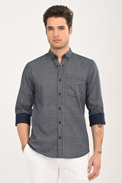 Man wearing a patterned shirt with rolled-up sleeves