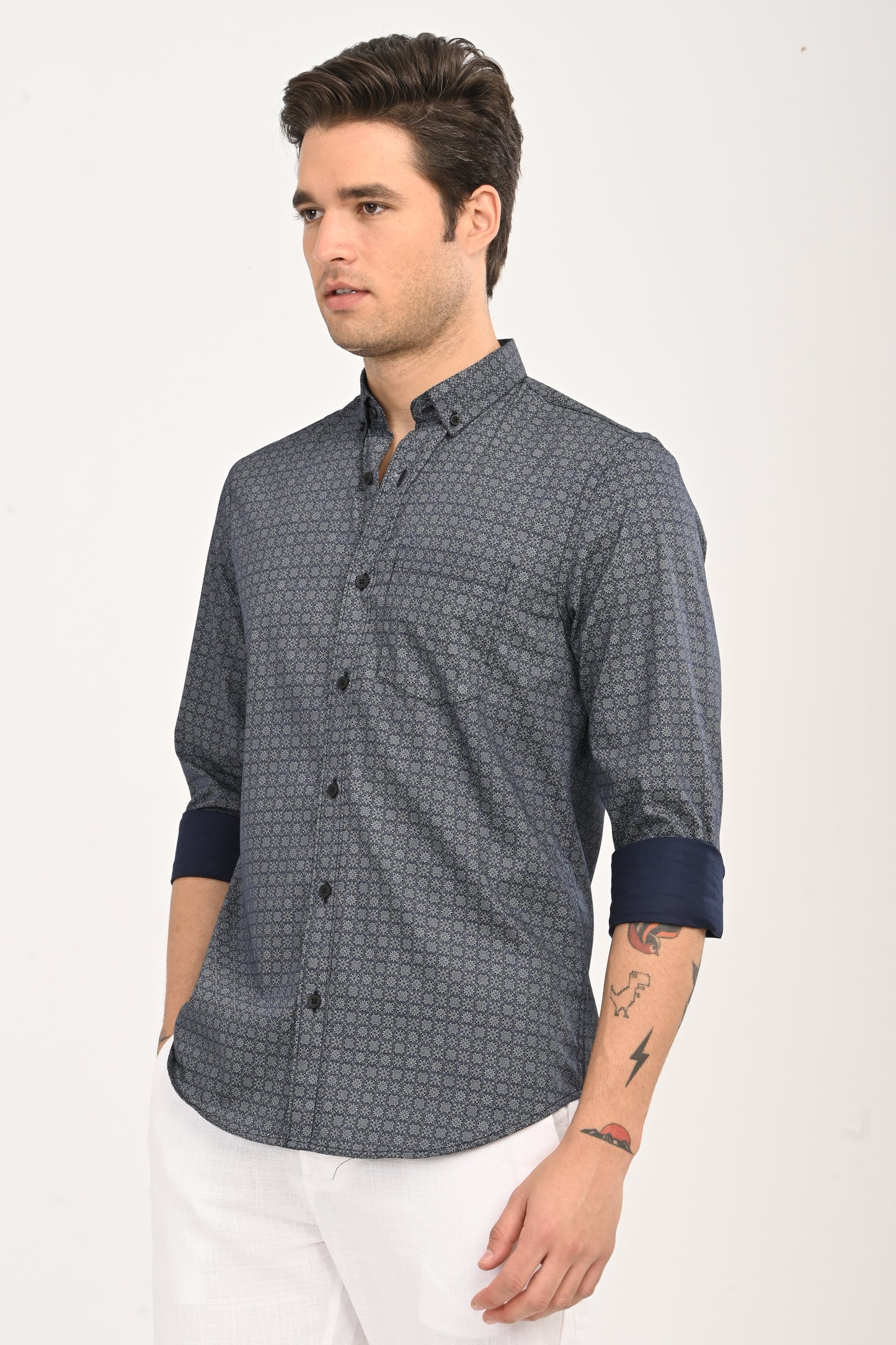 Man wearing a patterned shirt with rolled-up sleeves