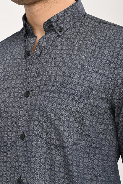 Man wearing a patterned shirt with rolled-up sleeves