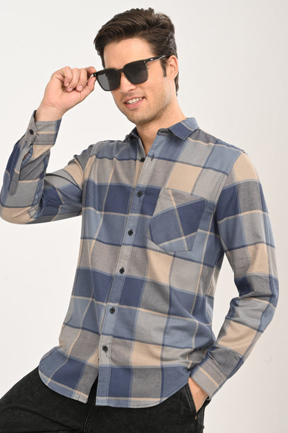 Front view of a model wearing a slate blue, navy, and beige large-block checkered casual shirt with black jeans.